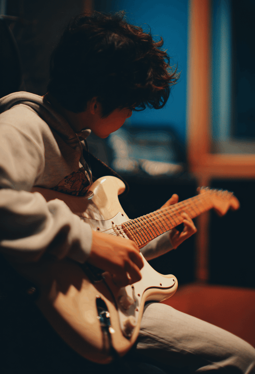 En pojke spelar elgitarr.